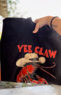 Black sweatshirt with 'Yee Claw' graphic design featuring a crawfish and cowboy hat.