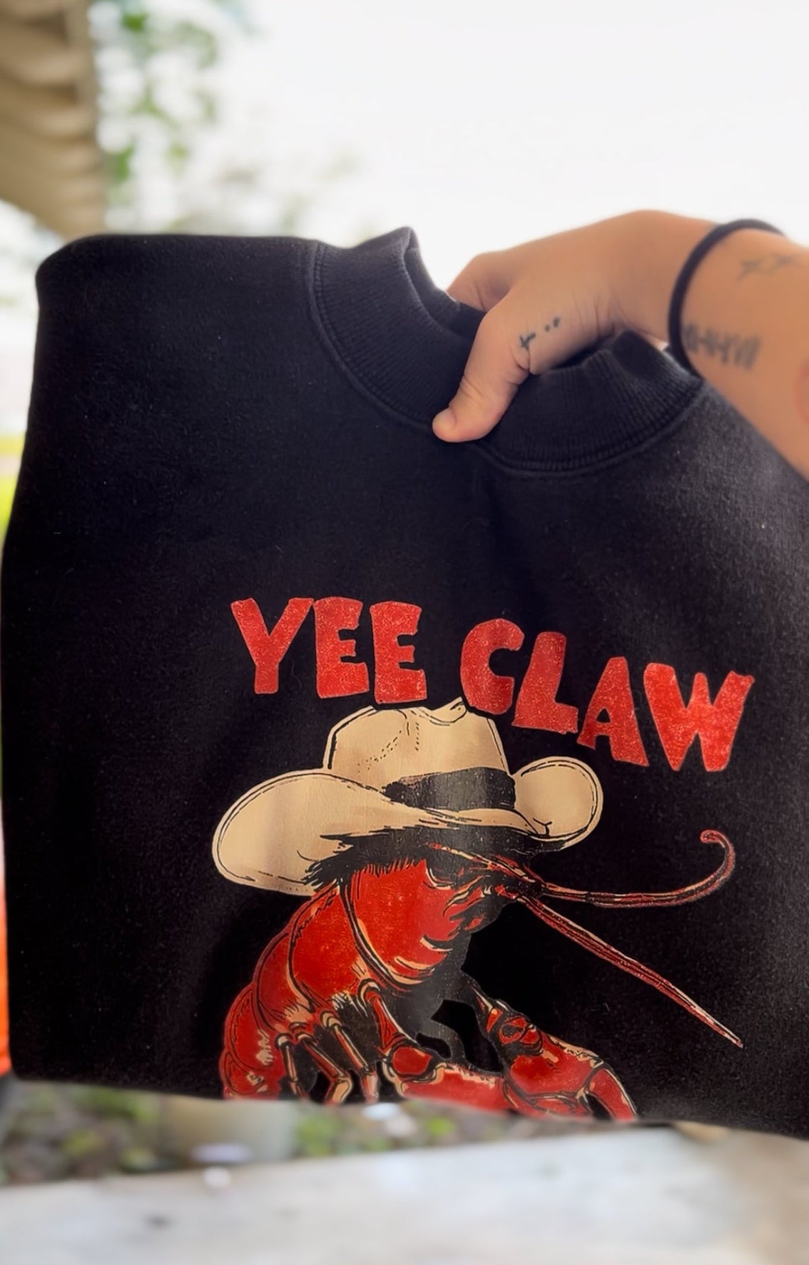 Black sweatshirt with 'Yee Claw' graphic design featuring a crawfish and cowboy hat.